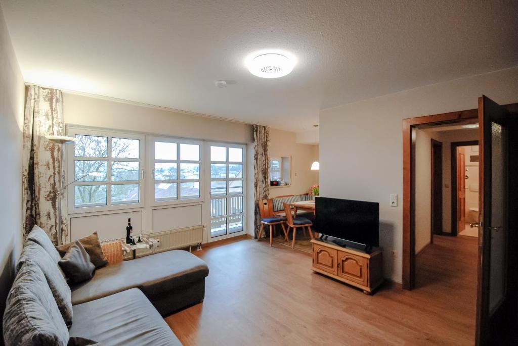 a living room with a couch and a television at Ferienwohnung Alte Hofmark Neumayer in Bad Birnbach