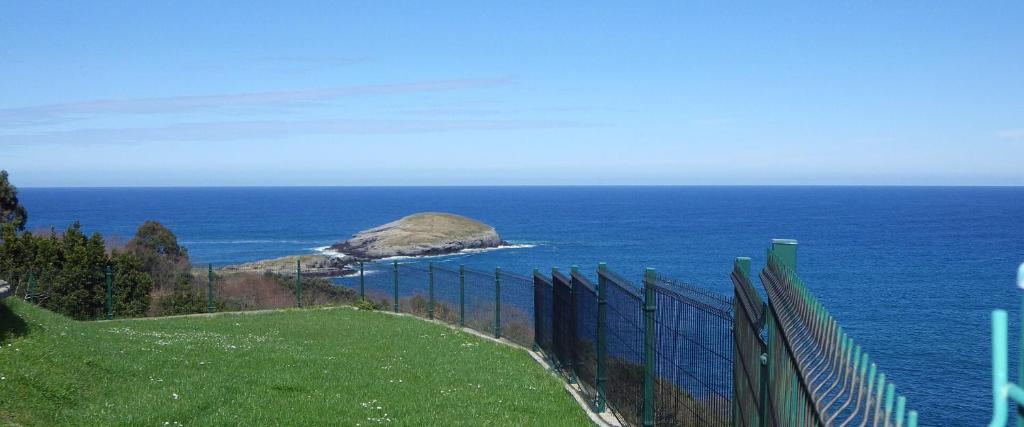 una valla en una colina con vistas al océano en Villa La Ballena de Sonabia, en Oriñón