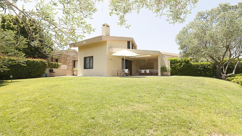 a house with a large lawn in front of it at #FLH - Mediterrané Pool Villa 1 in Sani Beach