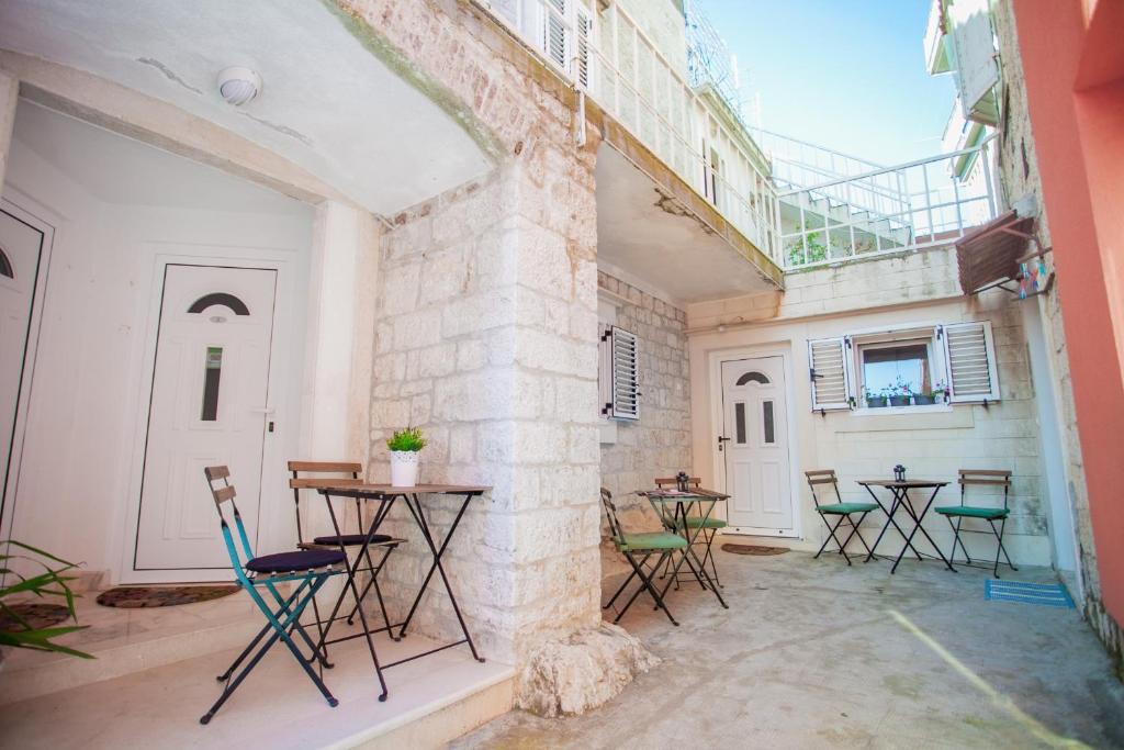 a patio with tables and chairs in a building at Apartments Emotha in Trogir