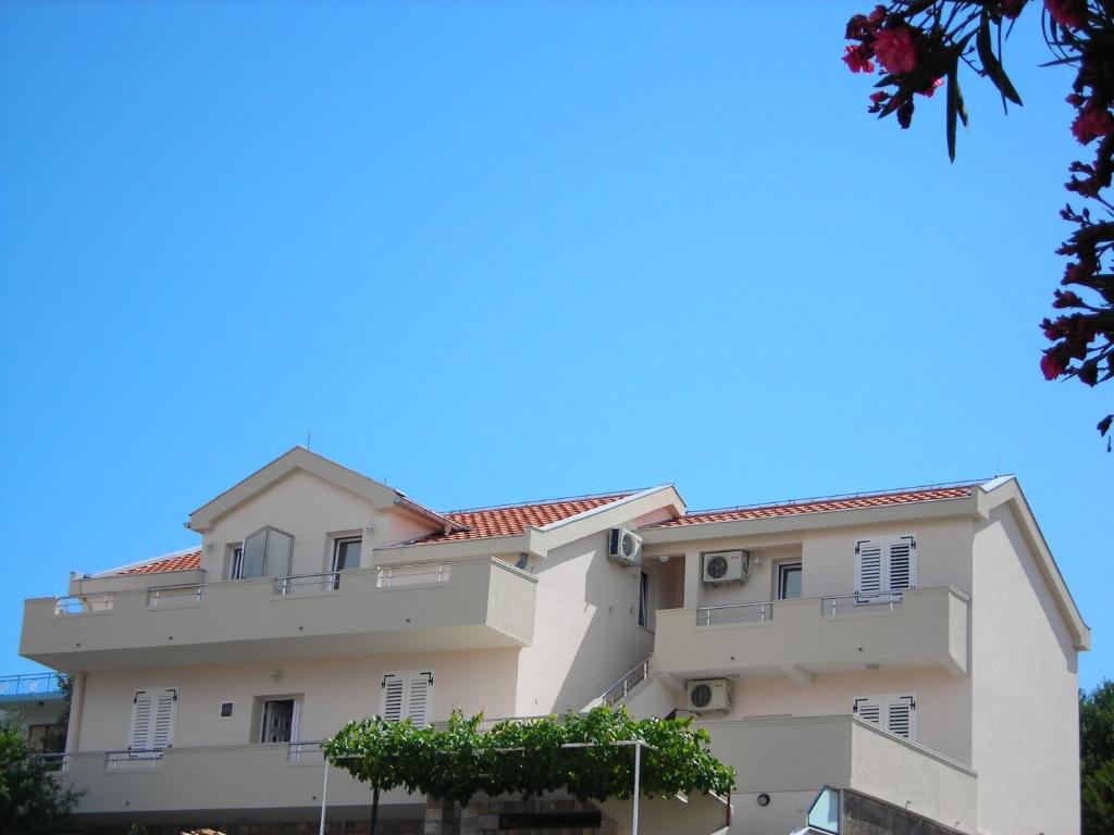 a large white building with a blue sky in the background at Apartments Stanjević in Tivat