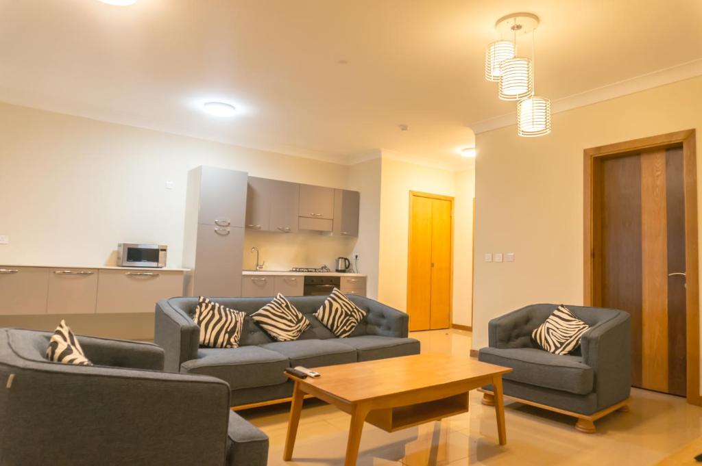 a living room with two couches and a table at Citadelle Mall Apartments in Port Louis