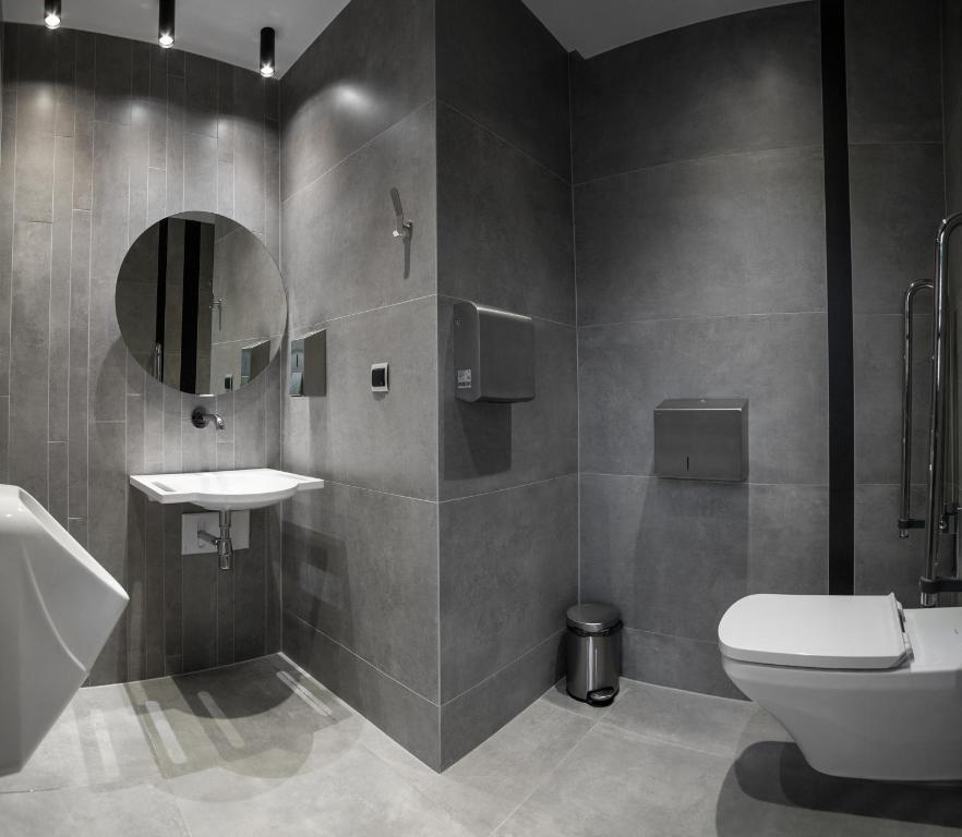 a bathroom with a toilet and a sink and a mirror at Hotel Alexander in Krakow