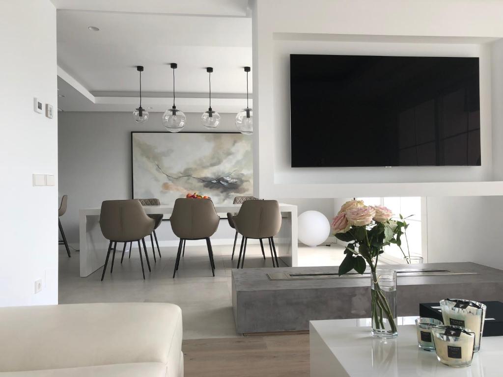 sala de estar con mesa y TV en la pared en Modern Apartment Puente Romano en Marbella