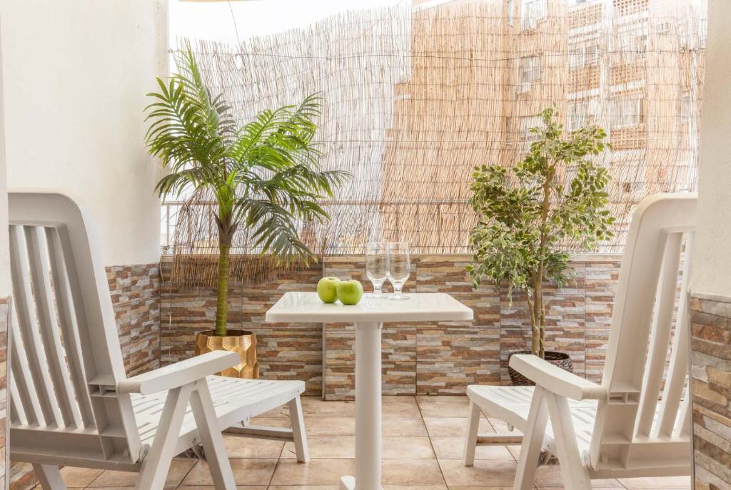 una mesa blanca con 2 sillas y fruta. en Atico Gran Terraza Triana, en Sevilla