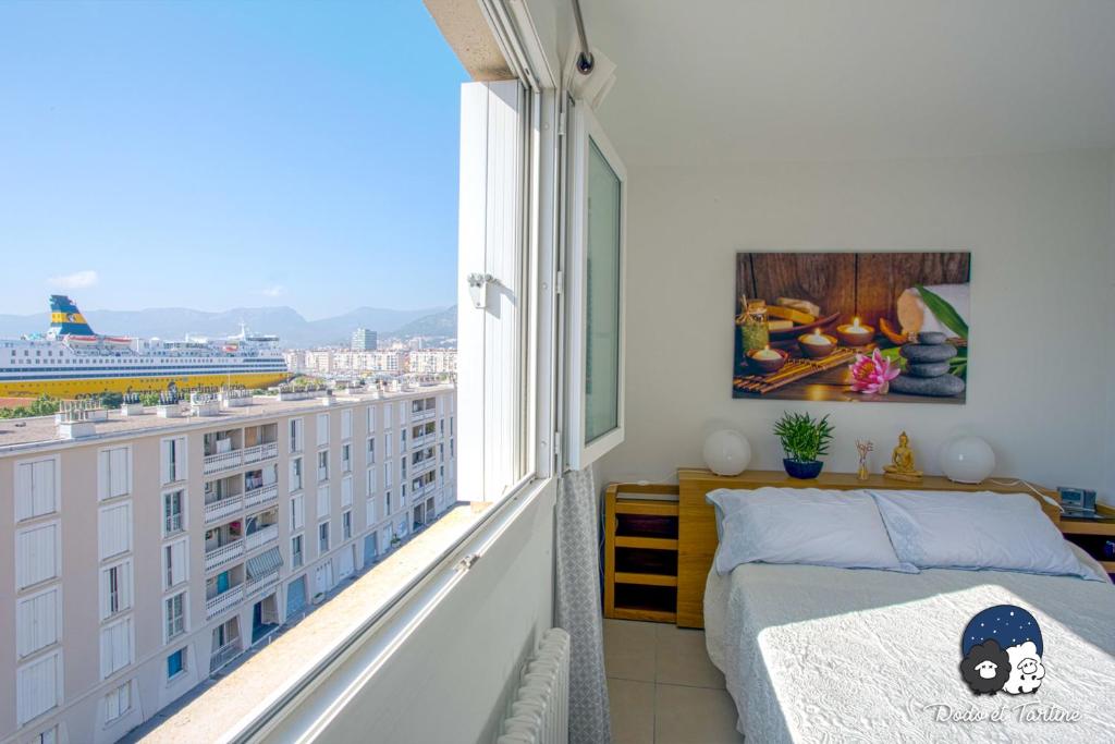 a bedroom with a bed and a large window at Spacious 2 bedroom near city centre - Dodo et Tartine in Toulon