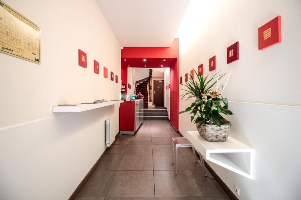 um corredor com uma porta vermelha e um vaso de plantas em Hotel Gambetta em Bordeaux