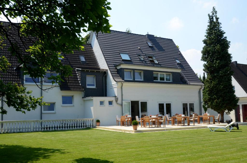 a large white house with a black roof at Hotel Destination 21 in Düsseldorf