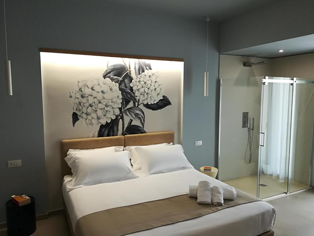 a bedroom with a bed with a painting on the wall at Villa Sece - Luxury Rooms in Agrigento