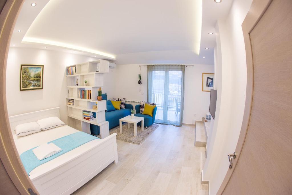 a bedroom with a bed and a living room at Apartment Novak in Budva
