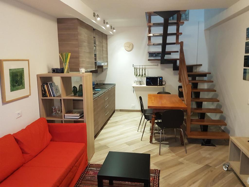 ein Wohnzimmer mit einem roten Sofa und einem Tisch in der Unterkunft La Corte sul Naviglio in Corsico