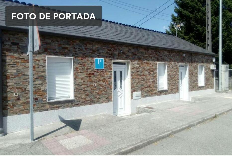 a brick building with a sign in front of it at Hospedaje Mendez in Lugo