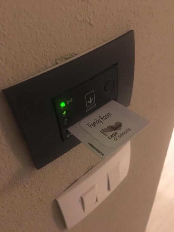 a lightswitch on a wall with a sign on it at Casa D'amore in Riomaggiore