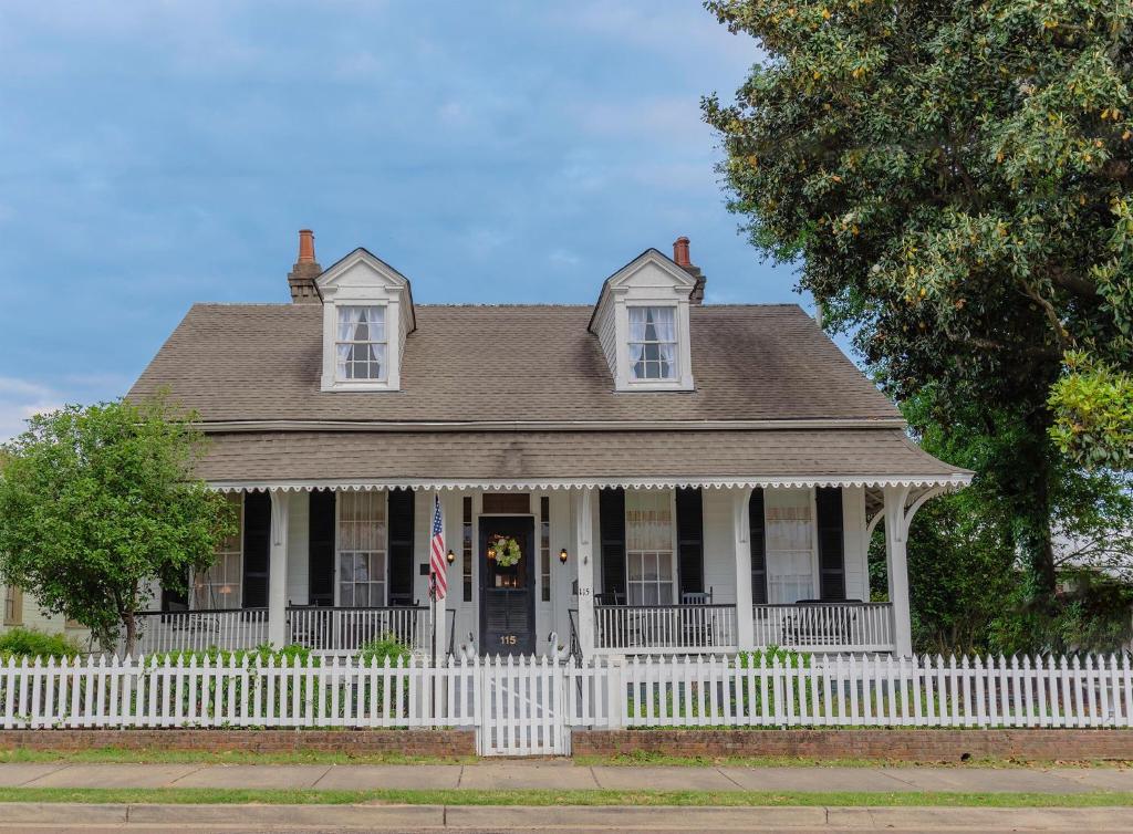 uma cerca branca em frente a uma casa em Riverboat Bed & Breakfast em Natchez