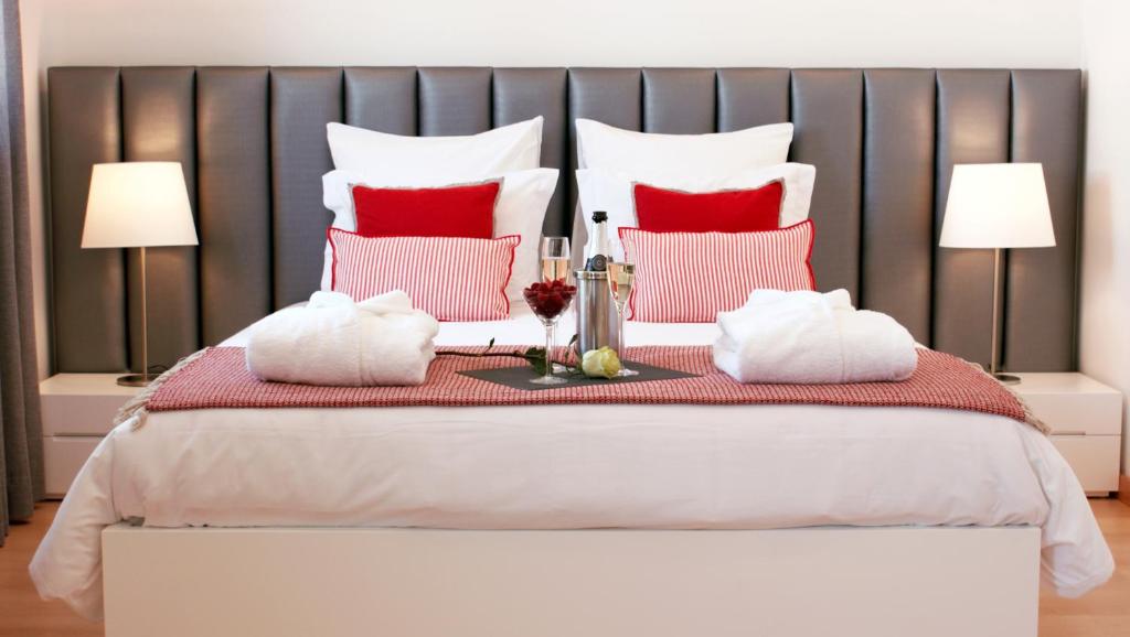 a bedroom with a large bed with red and white pillows at Ana's Apartments in Sines