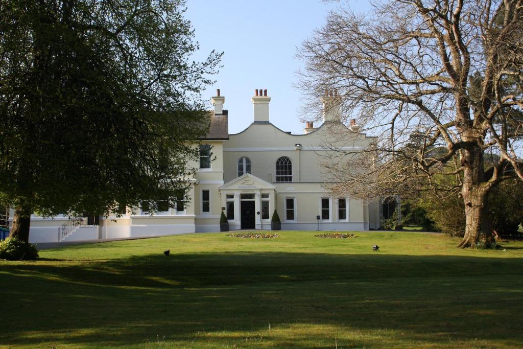 a large white house with trees in front of it at St Elizabeth's House in Plymouth