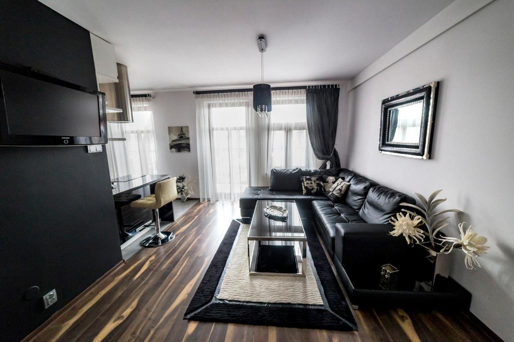- un salon avec un canapé noir et une table dans l'établissement Top Apartamenty, à Kielce