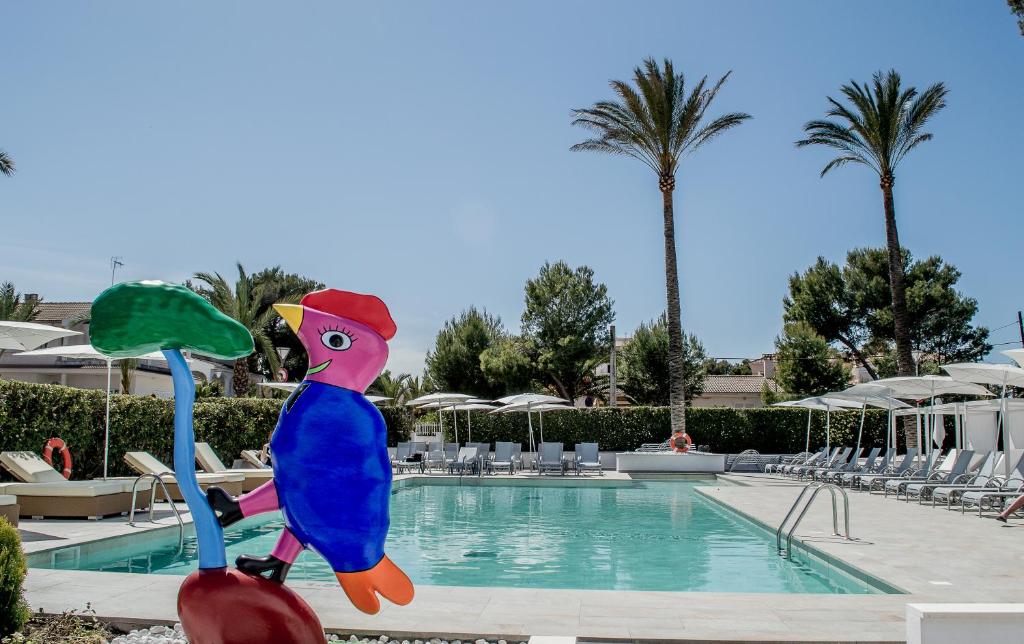 una estatua de un pájaro junto a una piscina en BQ Sarah -Adults Only en Can Picafort