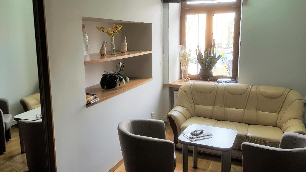 a waiting room with a couch and a table and chairs at Rodmos Hostel in Lublin