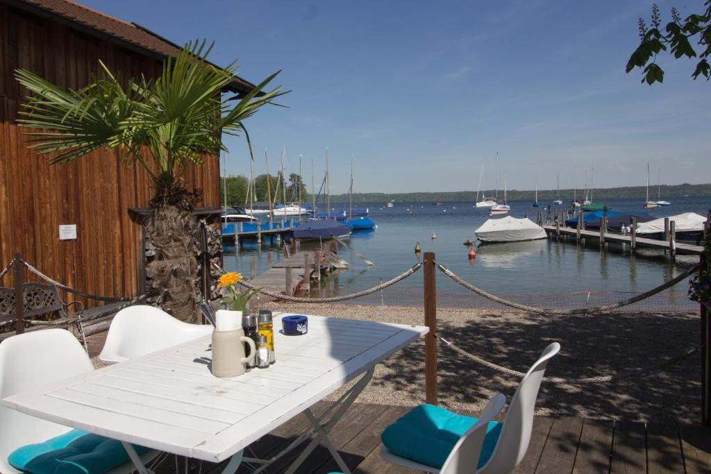 a table and chairs on a patio with a marina at Hotel am See in Tutzing