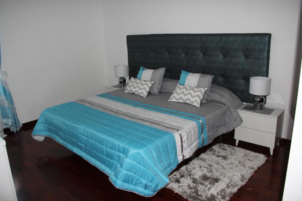 1 dormitorio con 1 cama grande con manta azul en Santa Luzia Apartment, en Funchal
