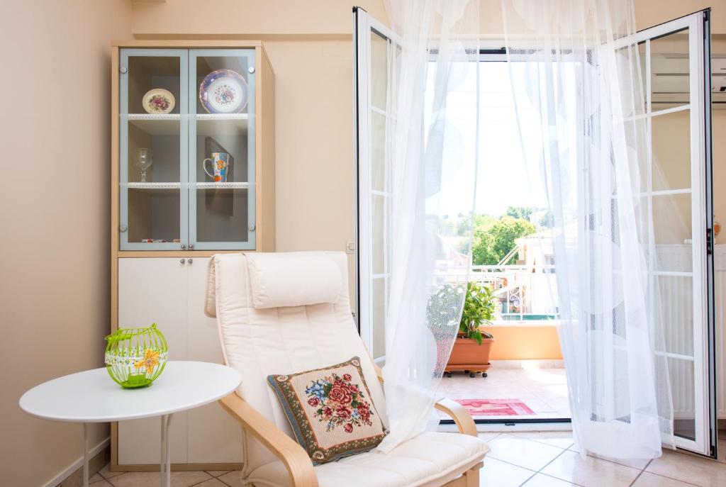 Pokój z białym krzesłem, stołem i oknem w obiekcie House of Velenia - 2 Bedroom apartment near old town, airport and bus station w Korfu