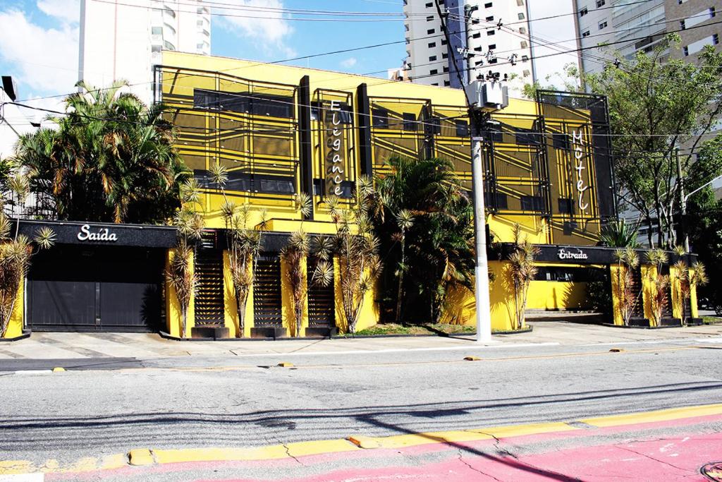 un edificio amarillo al lado de una calle en Elegance Motel, en São Paulo