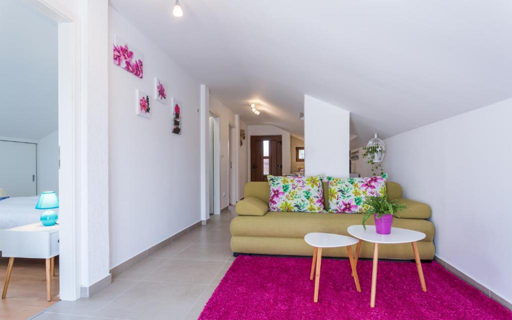 a living room with a couch and a pink rug at Apartment Deni in Krk