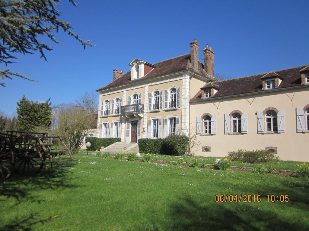 a large house with a grass yard in front of it at Domaine de Sainte Anne in Venoy