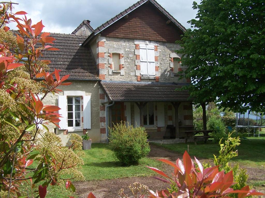 una vieja casa de ladrillo con ventanas blancas en un patio en Gite en Forterre, en Druyes-les-Belles-Fontaines