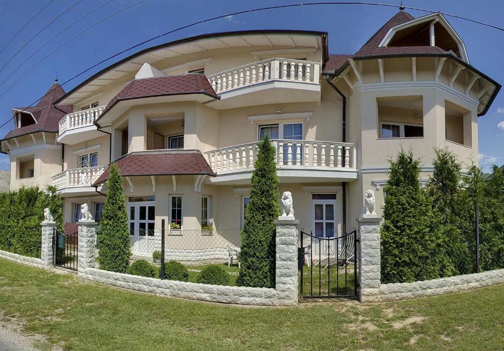 a large house with a fence in front of it at Hegyi Villa in Hévíz