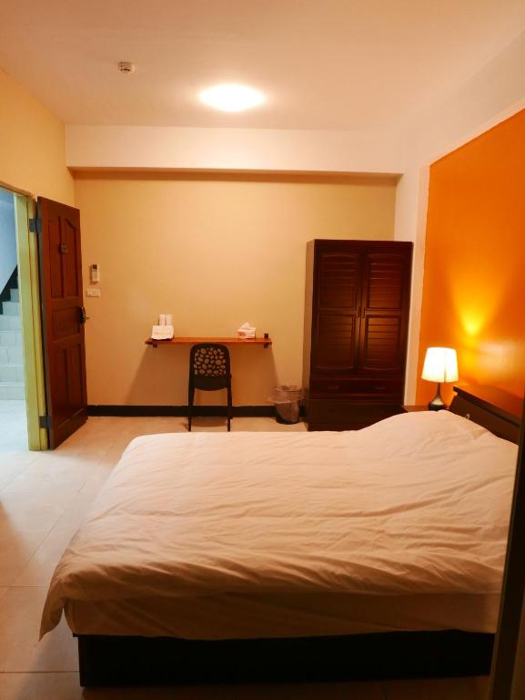 ein Schlafzimmer mit einem Bett und einem Tisch mit einem Stuhl in der Unterkunft 市區背包客棧-有套房及包棟 in Jincheng