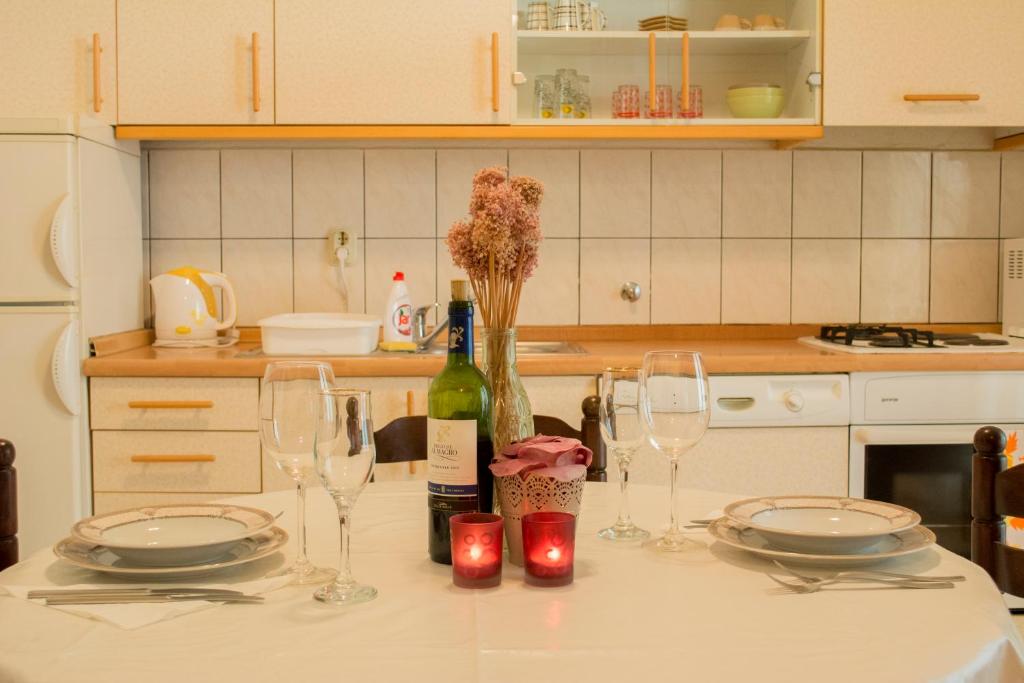 a kitchen counter with two glasses and a bottle of wine at Apartmani Eškinja in Biograd na Moru