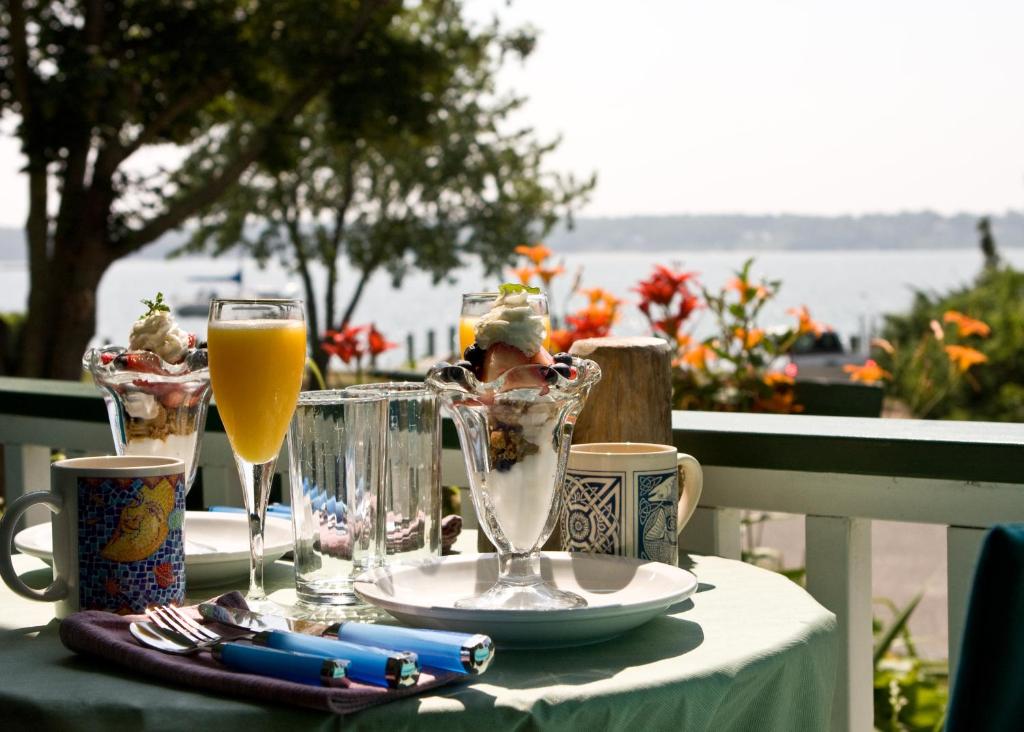 una mesa con un vaso de zumo de naranja y una bebida en The Stirling House Waterfront Inn Greenport, en Greenport