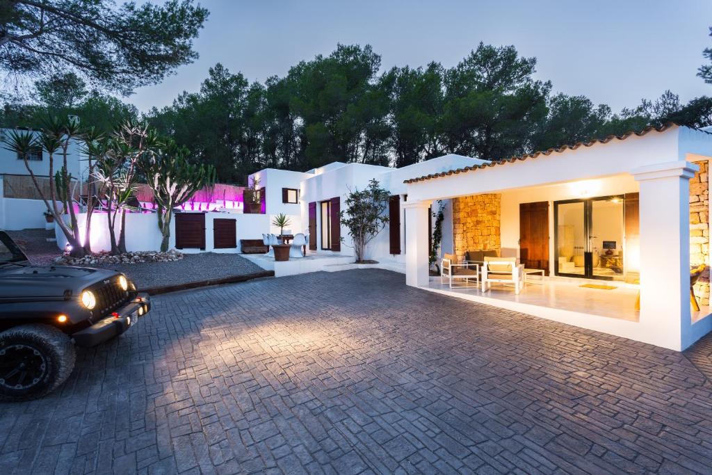 una casa con un coche aparcado delante de ella en VILLA CAN MASS Architect Country Villa, en Sant Rafel de sa Creu