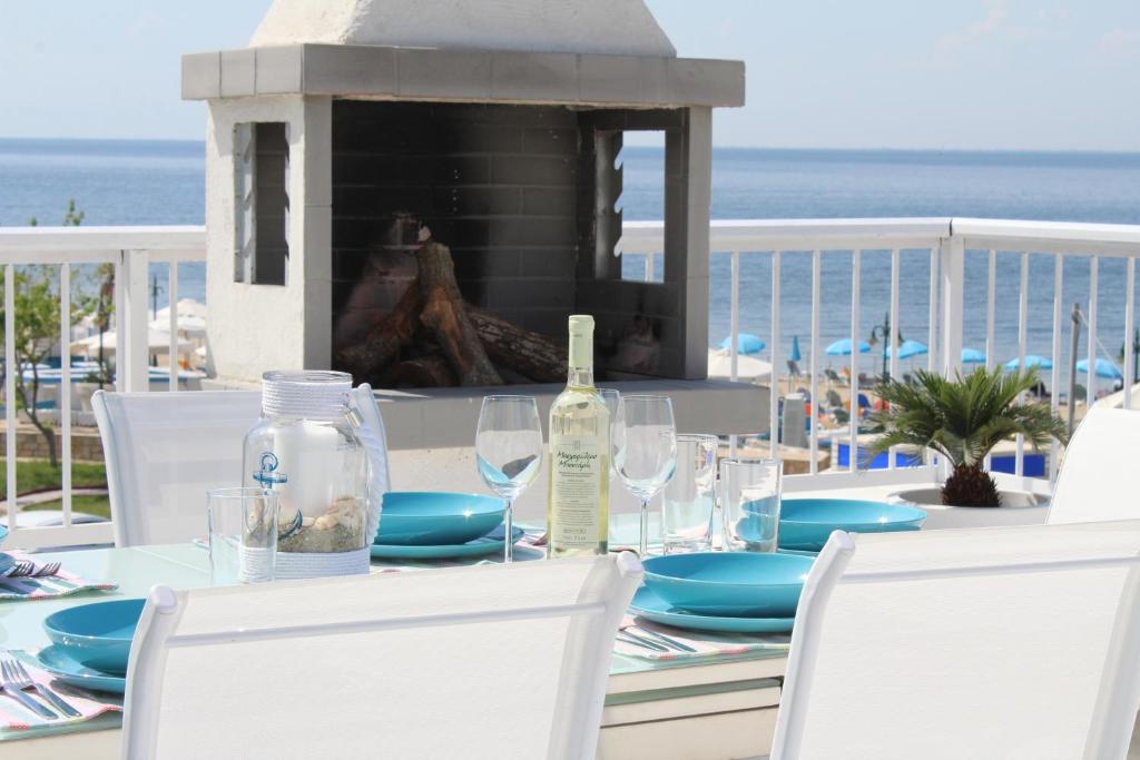 un tavolo con una bottiglia di vino e bicchieri in spiaggia di Riviera Home a Perea