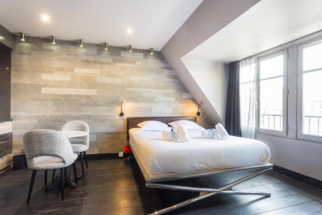パリにあるCMG - Suite Premium Tour Eiffel - 71のベッドルーム1室(大型ベッド1台、椅子2脚付)