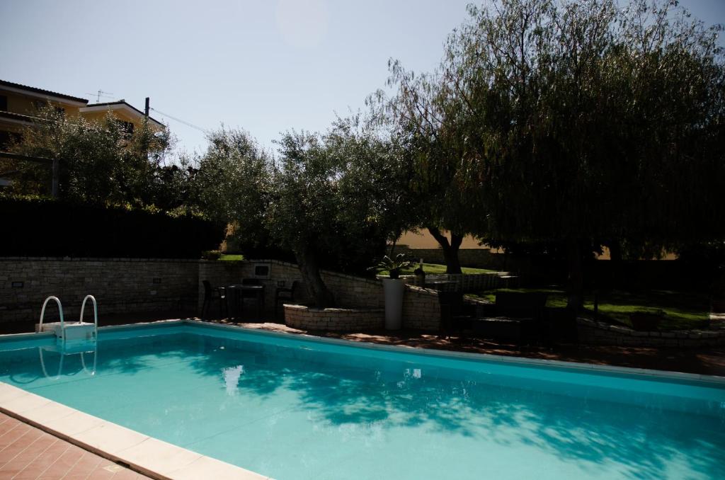 a swimming pool in a yard with trees at Lo Scacciapensieri in Francavilla al Mare