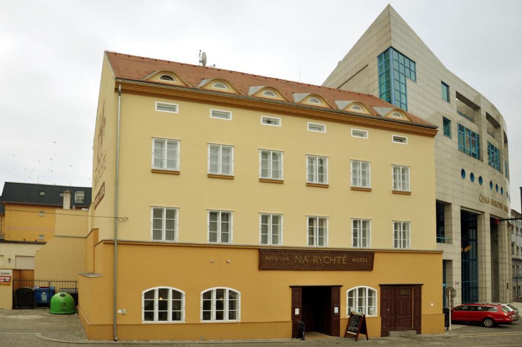 ein gelbes Gebäude vor einem hohen Gebäude in der Unterkunft Pivovar Hotel Na Rychtě in Ústí nad Labem