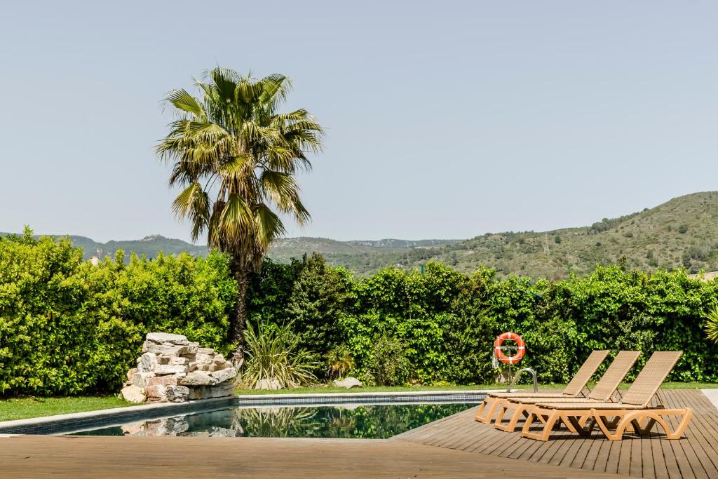 un patio avec deux chaises et une piscine dans l'établissement Crisol La Selva, à La Selva del Camp