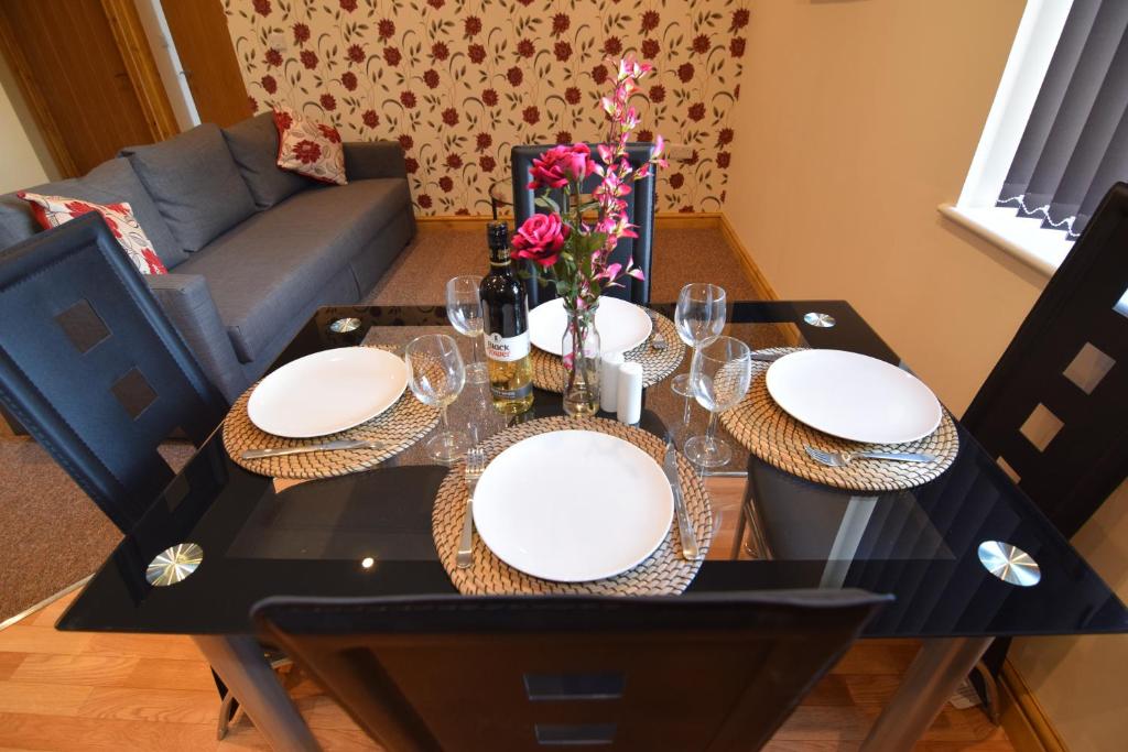 una mesa de comedor con platos y vasos. en Appleton Apartments en Newark upon Trent