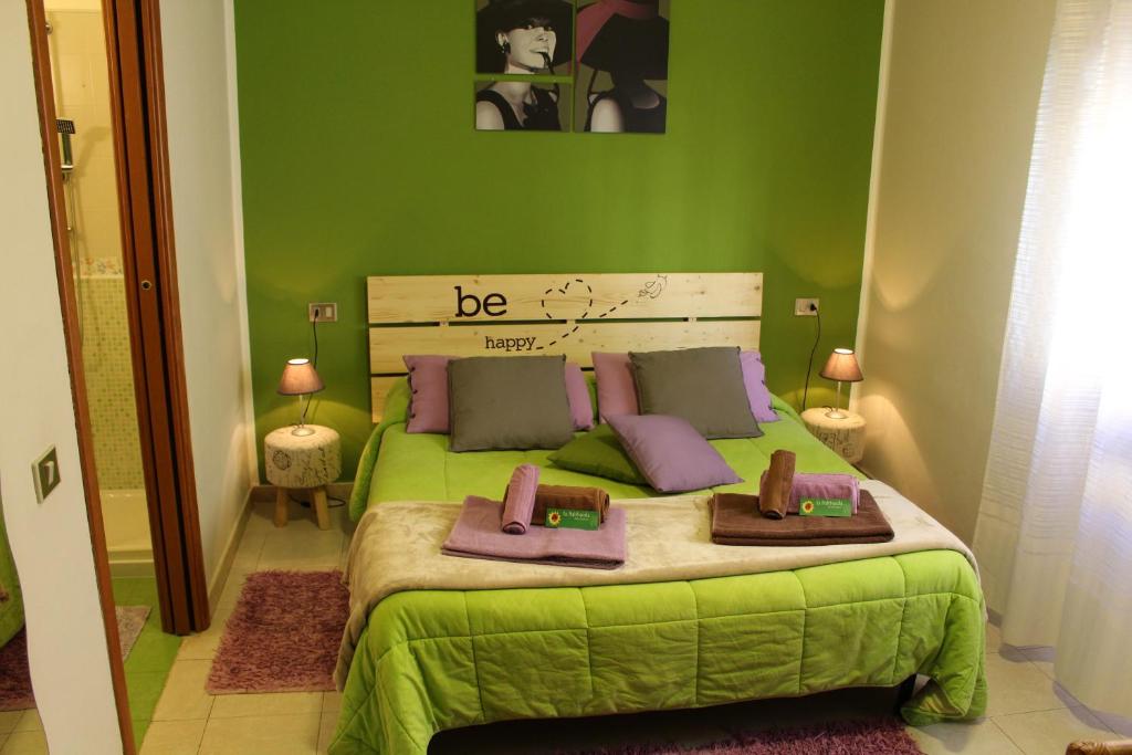 zieloną sypialnię z łóżkiem z 2 ręcznikami w obiekcie Sa Babbaiola w Cagliari