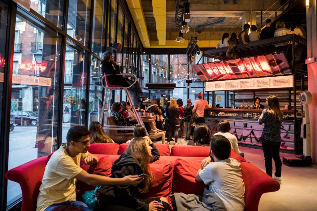 a group of people sitting on a red couch at Bastardo Hostel in Madrid
