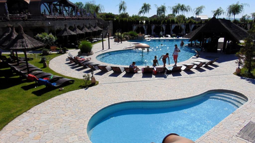 a swimming pool at a resort with people in it at Castel Transilvania in Baia Mare