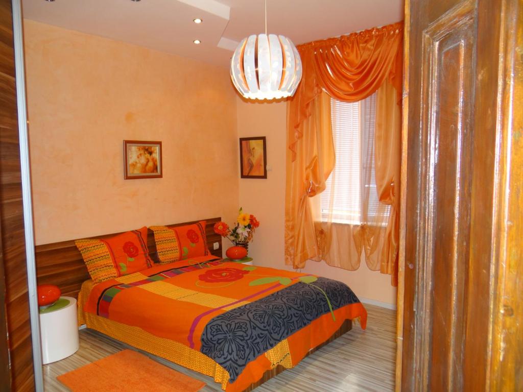Schlafzimmer mit einem Bett und einem Kronleuchter in der Unterkunft Orange Flower Apartments in Sofia