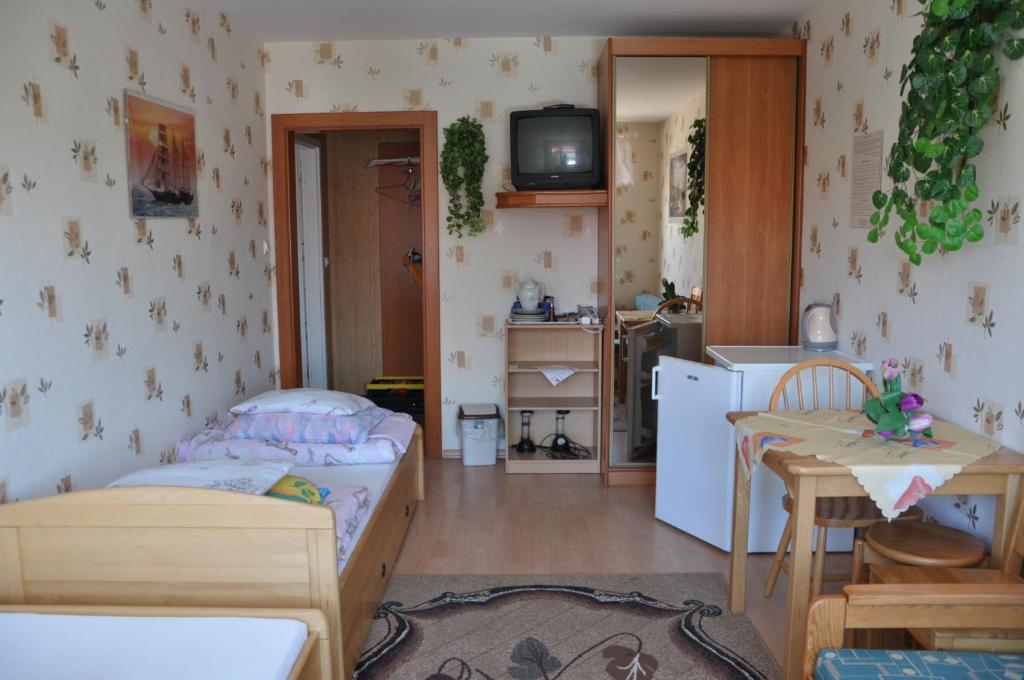 a small bedroom with a bed and a kitchen at Budziar - kwatery nad morzem in Darłowo
