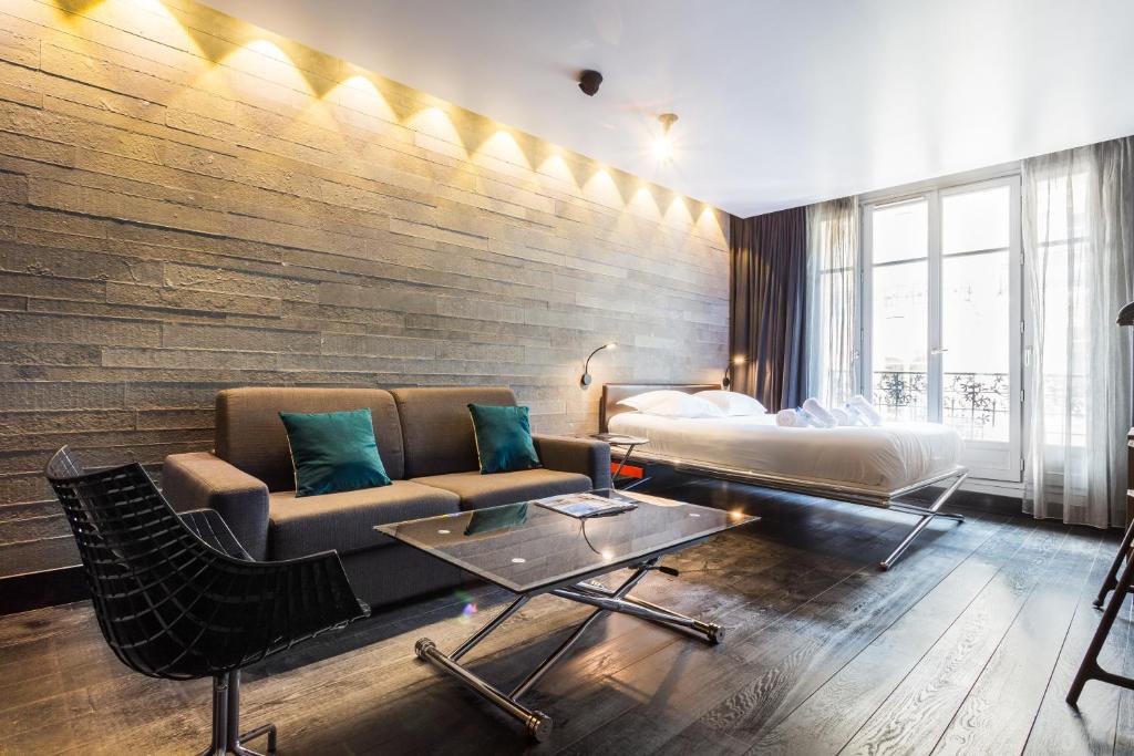a hotel room with a couch and a bed at CMG - Suite Premium Tour Eiffel - 51 in Paris