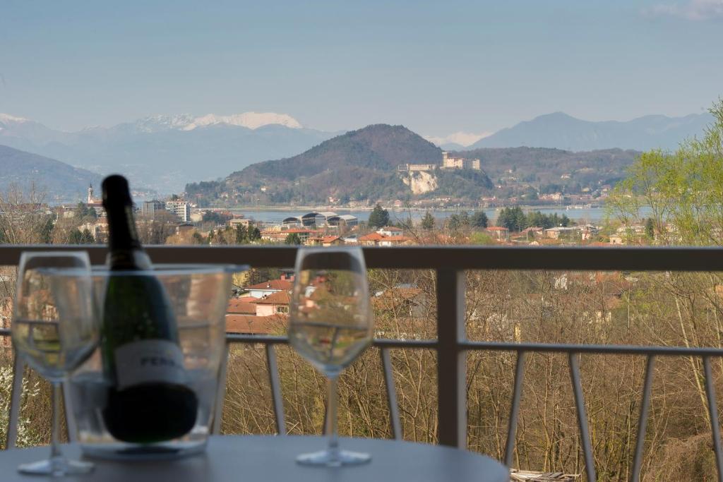 una bottiglia di vino seduta su un tavolo con due bicchieri di Little House With Lake View ad Arona