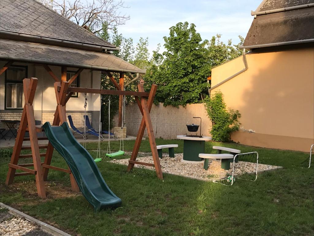 a playground in a yard with a slide at Tisza-Kert Apartmanok in Tiszafüred