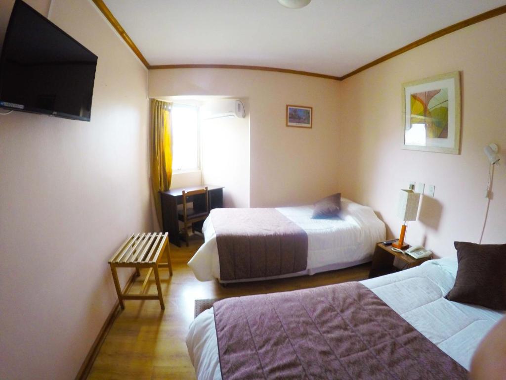 Habitación de hotel con 2 camas y TV de pantalla plana. en Hotel San Francisco De la Selva, en Copiapó